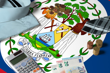 Belize flag on minimal money concept table. Coins and financial objects on flag surface. National economy theme.