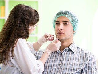 Plastic surgeon preparing for operation on man face