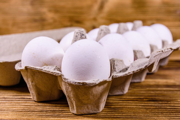 Pile of the hen eggs in paper tray on wooden table