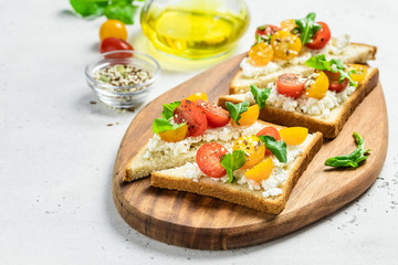 Cherry tomatoes goat cheese toasts. Selective focus, copy space.