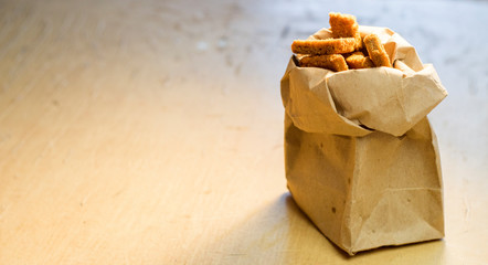 Paper bag with rye crackers on the table.