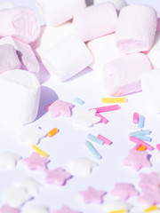 Obraz na płótnie Canvas Sugar colorful sprinkles, stars and marshmallows, baking decorations in multicolor, bright picture, home made bakery, White background and heavy shade