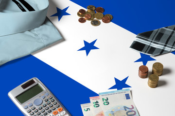 Honduras flag on minimal money concept table. Coins and financial objects on flag surface. National...
