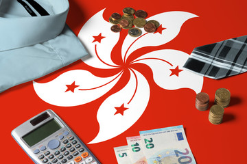 Hong Kong flag on minimal money concept table. Coins and financial objects on flag surface. National economy theme.