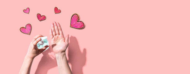 Applying sanitizer gel for cleaning hands with heart drawings