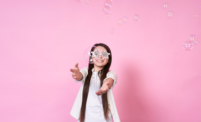Cute funny beautiful emotional young girl in stylish glasses, in a white T-shirt with air bubbles...