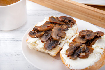 sandwiches with  cheese and mushrooms on a plate, a Cup of black coffee on a white background,