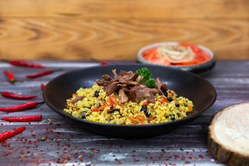Samarkand pilaf on the Uzbek plate and chuk chuk salad on the wooden background