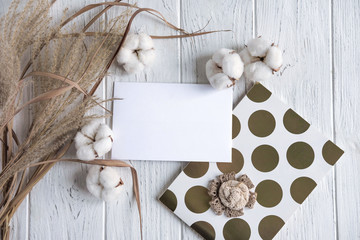 Mock up with cotton flowers and dried flowers on a light wooden background. Rustic frame for text with dried herbs and flowers. Winter background with flowers