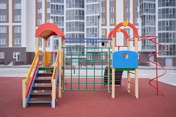 Fototapeta na wymiar New Playground for children, in the background of a new apartment building. Territory improvement concept