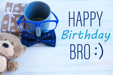 Happy Birthday bro. Brother and friend birthday greeting card design. Tie butterfly, cup and toy bear.