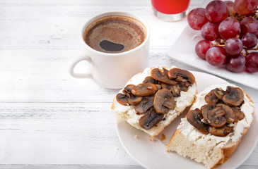 sandwiches with cheese and mushrooms,  Cup of black coffee, grapes on a white ,  delicious, healthy Breakfast, copy space