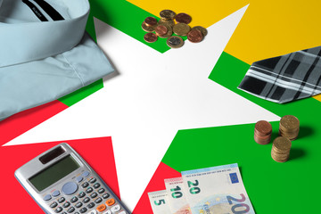 Myanmar flag on minimal money concept table. Coins and financial objects on flag surface. National economy theme.