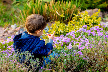 little todler playing with flowers in the garden