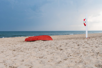 Red boat on white beach with lifesaver near Skagen, Denmark