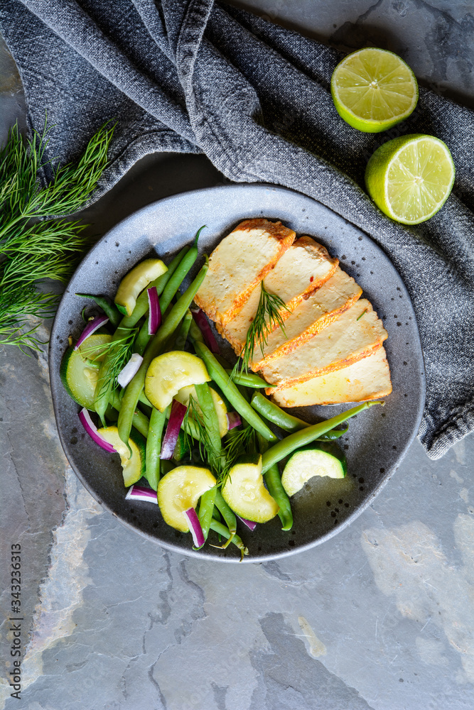 Wall mural Marinated tofu slices served with blanched green beans and zucchini, drizzled with olive oil and decorated with fresh dill - Wall murals