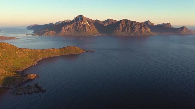 aerial view. flight over the sea,view on the Flakstadoya from Haukland beach and Mannen peak. Camera move left to right .Lofoten Islands,Norway