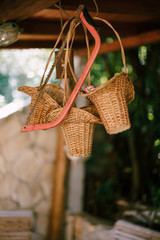 Three wicker baskets and a red saw hang under the ceiling