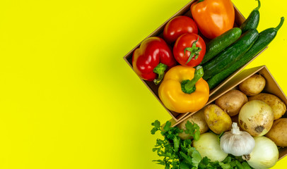 Food. Quarantine food crisis. Isolation on yellow. Box of vegetables products. Tomatoes, cucumbers, peppers, onions, herbs. Food delivery, donation, coronavirus.