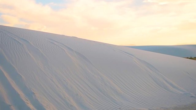 White sand dunes slow motion horizontal panorama panning in New Mexico desert national monument hill during sunset landscape scenery