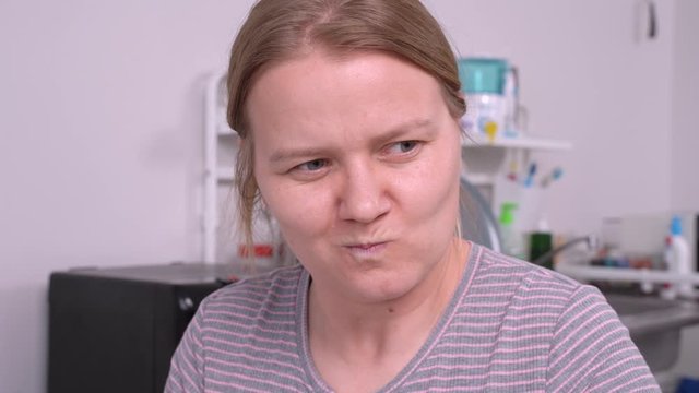 Cunning blonde girl with sarcastic face is plotting some dirty trick. Bitchy wife makes insidious plans against husband. Woman recalls her enemies or unpleasant incident.