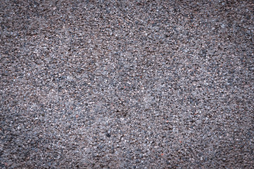 Gravel, concrete wall, asphalt texture. Grey concrete background made of small pebbles with a vignette around the edge