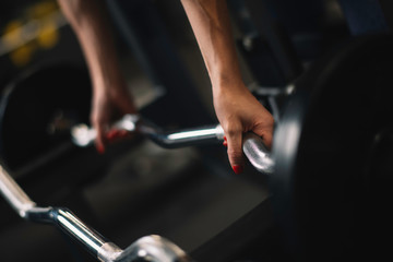 Close up of woman with dumbbells. Young woman in the gym.