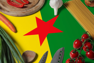 French Guiana flag on fresh vegetables and knife concept wooden table. Cooking concept with preparing background theme.