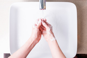 Washing hands with soap in the bathroom