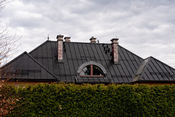 Fototapeta na wymiar black roof with four chimneys