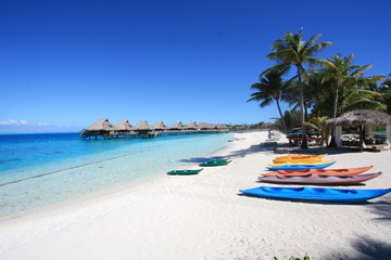 Exotic paradise travel concept. Beach Tropical luxury with canoe, kayac, paddle tables and lot of sport activities in Bora Bora, Tahiti, French Polynesia. - obrazy, fototapety, plakaty