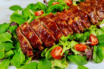 Delicious pork ribs with green salad and tangy BBQ sauce.
