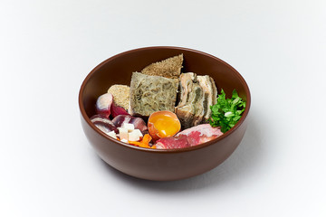 Natural raw dog food in bowl. Natural meat products vegetables egg vitamins and supplements. Organic pet food. Close up
