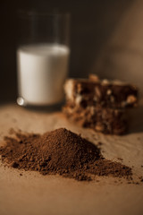Chocolate muffins with milk on a dark background. Cocoa powder, chocolate muffin and a glass of milk