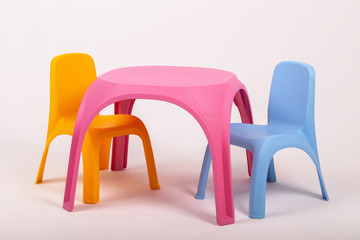 yellow plastic childrens table and two chairs on white background