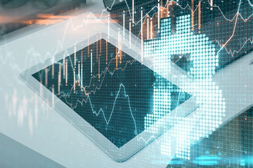 Digital tablet on desktop with bitcoin symbol