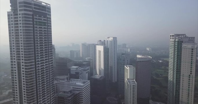 Ascending Aerial Flight towards High Rise Buildings with an Urban City View of Manila, Philippines
