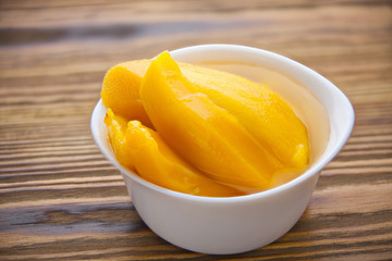 Naklejka na ściany i meble Tasty ripe appetizing mango on plate on the table