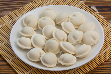 Fototapeta na wymiar Raw frozen dumplings on plate on table