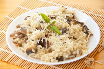 Tasty appetizing risotto on  white plate on  wooden table