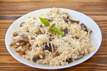 Tasty appetizing risotto on  white plate on  wooden table
