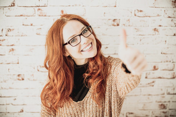 red haired beauty with thump up smiling in camera