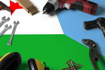 Djibouti flag on repair tool concept wooden table background. Mechanical service theme with national objects.