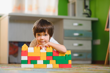 Little child playing with lots of colorful plastic toys at home. educational games at home or in kindergarten