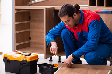 Young handsome male carpenter working indoors