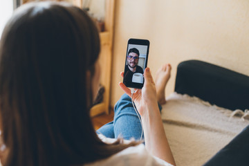 Young woman doing video chat with men at home. Staying home during quarantine.