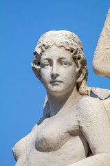Fototapeta na wymiar old sculpture of woman in bright sunlight