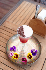 Red cocktail with froth and chocolate shavings