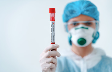 Negative COVID-19 test. Virologist in a medical mask and protective suit holds a test tube with...
