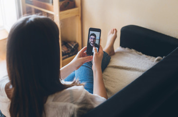 Young woman doing video chat with men at home. Staying home during quarantine.